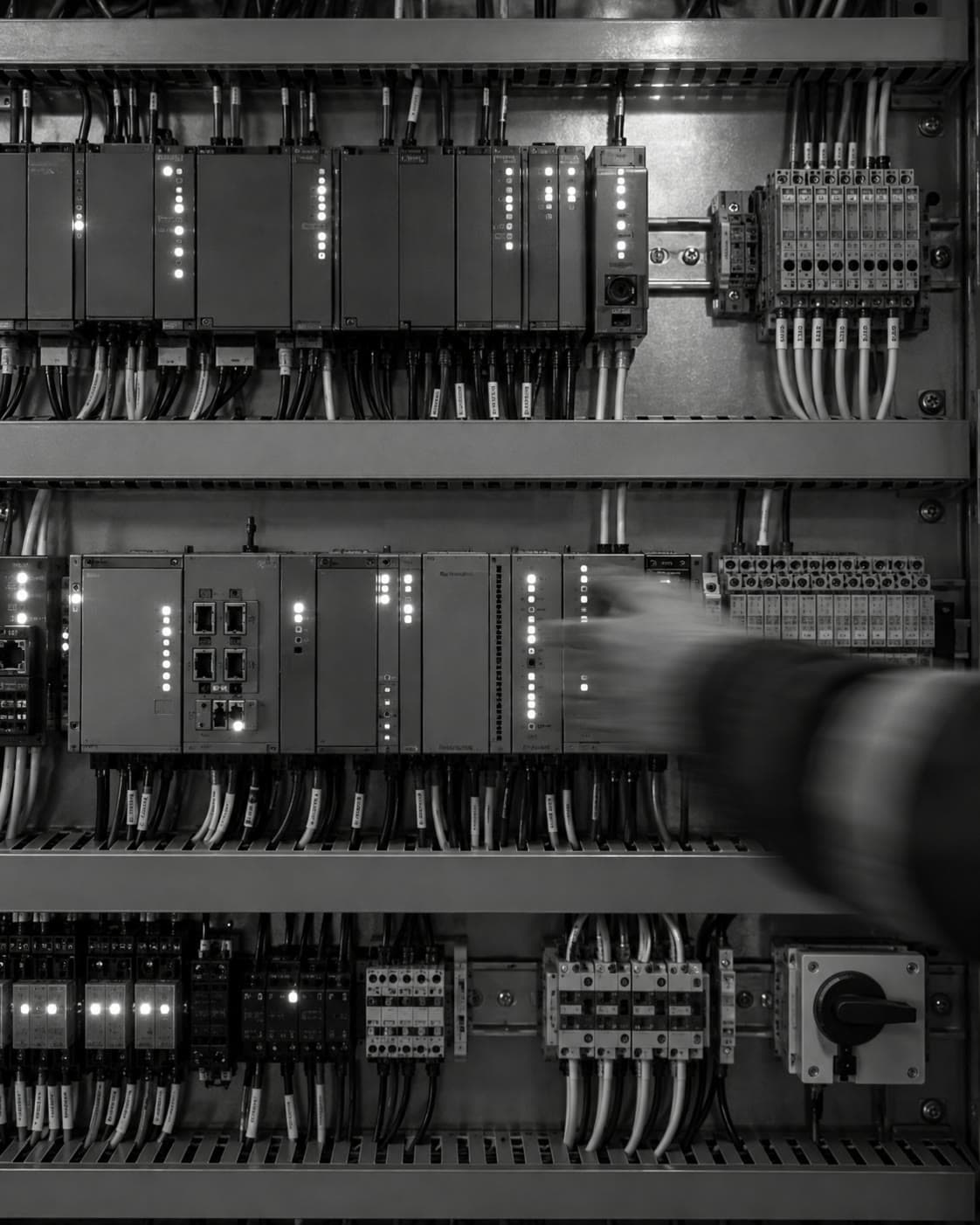 Reference photograph: a controls panel with a technician’s hand blurred in motion